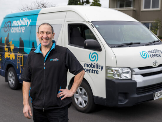 Mobility Centre Technician Ifan stands in front of his service van. He is smiling and ready to help.