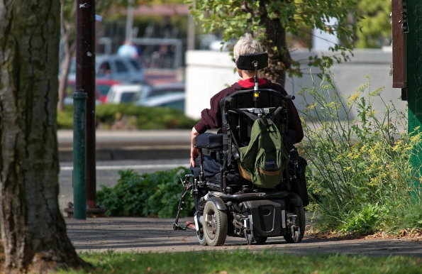 A person with Motor Neurone Disease using a Wheelchair Mobility Aid.